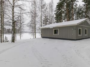 Ein Schuppen im Schnee mit Fußabdrücken im Schnee in der Unterkunft Holiday Home Muikku by Interhome in Hiukkajoki
