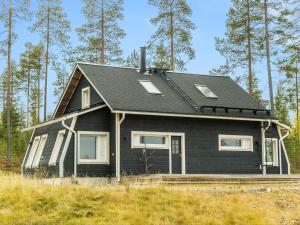 a black house in the middle of a field at Holiday Home Aurora by Interhome in Narkaus