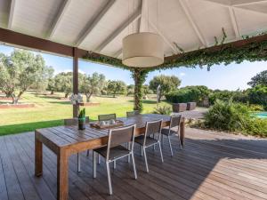 an outdoor dining room with a wooden table and chairs at Holiday Home Villa Lavezzi by Interhome in Bonifacio