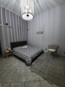 ein Schlafzimmer mit einem Bett, einem Stuhl und einem Kronleuchter in der Unterkunft B&B L'annunziata in Bari