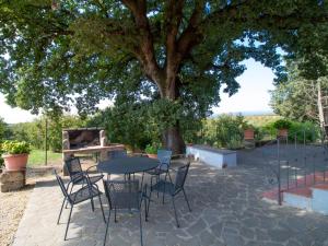 a table and chairs under a tree with a piano at Villa La Quercia by Interhome in Vasanello