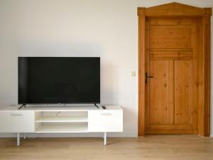 a television on a white entertainment center with a door at Apartment Am Rotenberg by Interhome in Detmold +21 photos