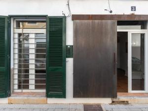 um edifício com persianas verdes e uma porta em Holiday Home Robin by Interhome em Sa Pobla