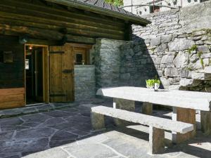 a stone bench sitting in front of a stone building at Holiday Home Rustico Gianni by Interhome in Malvaglia