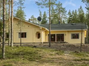 une maison jaune avec des arbres devant elle dans l'établissement Holiday Home Sallan saaga by Interhome, à Tikkala