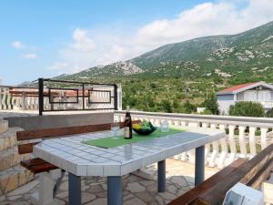 a table with a bottle of wine on a balcony at Holiday Home Golic - KBG302 by Interhome in Karlobag