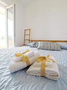 - un lit avec des serviettes et des arcs au-dessus dans l'établissement Sunrise - Appartamento con terrazzo fronte mare, à Spadafora