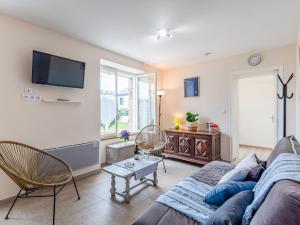 a living room with a couch and a tv at Holiday Home Les palmiers by Interhome in Saint-Philibert