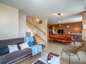 a living room with a couch and a pool table at Holiday Home Les palmiers by Interhome in Saint-Philibert