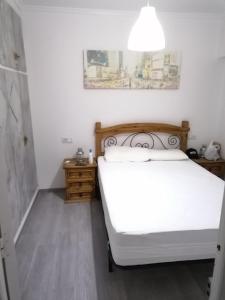 トレビエハにあるAppartement Avec Piscine Proche De La Merのベッドルーム(白いベッド1台、ランプ付)