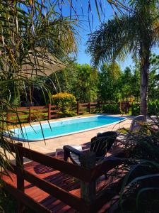 una piscina con una terraza de madera y un banco en Cabañas Pulmahue en Colón