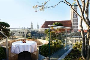 a table on a balcony with a view of the city at Hotel Bayerischer Hof in Munich