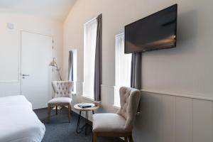 a room with a bed and a tv on a wall at Hotel Molenzicht in Nes