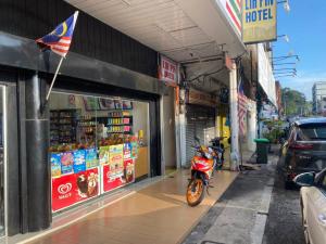 a motorcycle parked in front of a store at Lih Pin Hotel in Sungai Petani