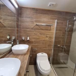 ein Badezimmer mit zwei Waschbecken, einem WC und einer Dusche in der Unterkunft Cerveceria y Hosteria Lican in Villarrica