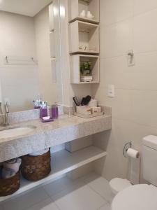 a bathroom with a sink and a toilet at EXCELENTE APARTAMENTO ENTRE A LAGOA E O MAR!!! in Arraial do Cabo