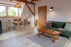 a living room with a green couch and a table at Ferienwohnung Kogeler See in Kogel