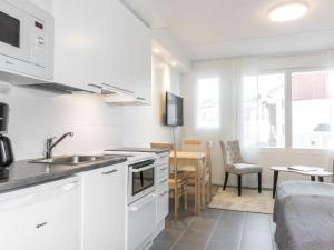 una cucina bianca con lavandino e tavolo di Holiday Home Skistar 315 by Interhome a Levi