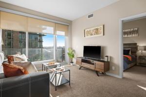 a living room with a couch and a large window at Stylish Downtown Condos by GLOBALSTAY in Calgary