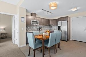 a kitchen with a wooden table and blue chairs at Stylish Downtown Condos by GLOBALSTAY in Calgary