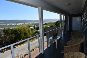 a balcony with chairs and a view of the ocean at Friendz Guesthouse in Knysna
