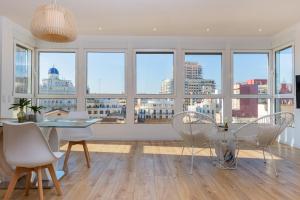 a dining room with a table and chairs and windows at Ayuntamiento Panoramic in Valencia