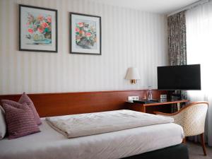 a hotel room with a bed and a television at Parkhotel in Bad Wünnenberg