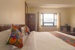 a bedroom with a large white bed with a window at FabHotel Kutighar Regency in Gangtok
