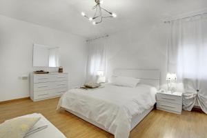 La Casa Di Gemma & Regina Oriente في البندقية: غرفة نوم بيضاء مع سرير كبير ودواليب بيضاء