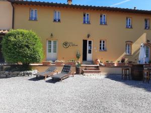 a house with two benches in front of it at B&B Alloro in Capannori