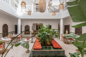 un vestíbulo de un hotel con plantas y mesas en Riad Babouchta & Spa, en Marrakech