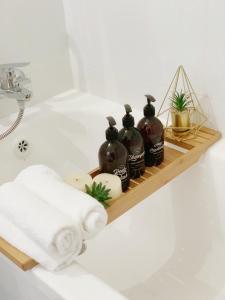 a bathroom shelf with four bottles of soap and towels at Sea view penthouse Private rooftop jacuzzi in Eilat +26 photos