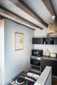een keuken met een fornuis en een magnetron bij GITE DE L'ORME in Sancerre