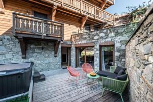 a patio with a couch and chairs on a wooden deck at Apartment Padouk Moriond Courchevel - by EMERALD STAY in Courchevel