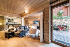 a living room with a couch and a table at Apartment Padouk Moriond Courchevel - by EMERALD STAY in Courchevel