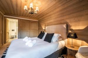 Schlafzimmer mit einem großen weißen Bett und Holzwänden in der Unterkunft Apartment Padouk Moriond Courchevel - by EMERALD STAY in Courchevel