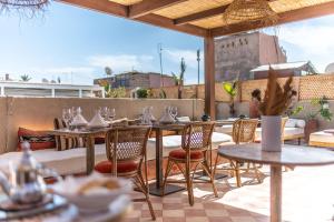 ein Restaurant mit Tischen und Stühlen auf einer Terrasse in der Unterkunft Riad Babouchta & Spa in Marrakesch