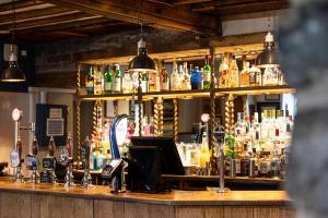 a bar with a lot of bottles of alcohol at The Castle by Innkeeper's Collection in Castleton