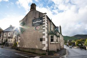 um velho edifício de tijolos ao lado de uma rua em The Castle by Innkeeper's Collection em Castleton