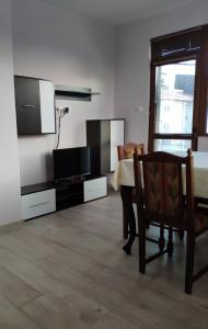 a living room with a table and a tv at LILIYA Apartment in Pleven