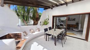 jadalnia ze stołem i krzesłami na patio w obiekcie Casa EL JARDIN w mieście Morro del Jable