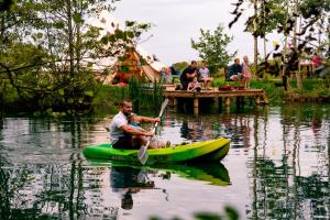 a man in a green kayak in the water at Arcadia Safari Tent in private 5 acre field in Wrexham