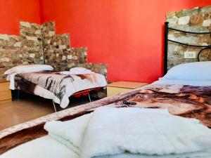 two beds in a room with red walls at Albergo Ristorante Dal Cogo in Spert