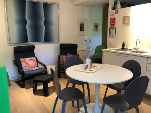 una camera con tavolo e sedie e una cucina di Linden-Jachthoorn a Lubbeek