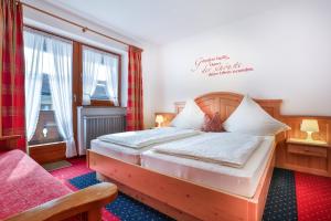 ein Schlafzimmer mit einem Holzbett in einem Zimmer in der Unterkunft Haus am Reschenberg Ferienwohnungen in Ramsau bei Berchtesgaden