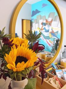 a vase filled with sunflowers in front of a mirror at The Stirling Arms Pub & Rooms in Brighton & Hove