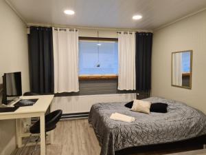 1 dormitorio con cama, escritorio y ventana en Ellivuori Resort, en Sastamala