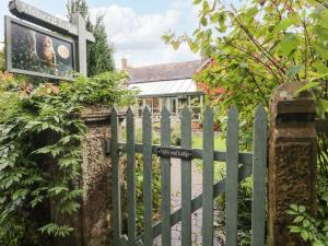 a green fence with a sign in front of a house at Millwood Lodge in Barrow in Furness