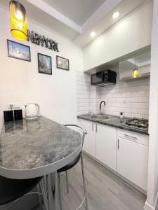 uma cozinha com uma mesa e uma bancada em Apartment Studio New York 51 em Irpin