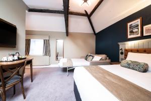 a hotel room with two beds and a desk at The Castle by Innkeeper's Collection in Castleton +22 photos